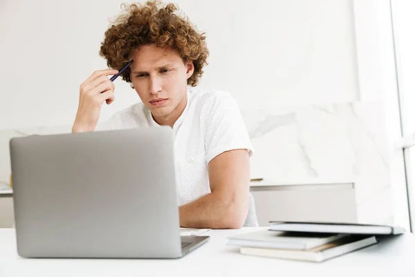 Guapo hombre serio concentrado usando ordenador portátil . — Foto de Stock