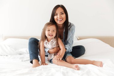 Küçük kızını sarılma mutlu genç kadın