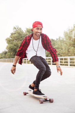 Genç koyu tenli adam kaykay
