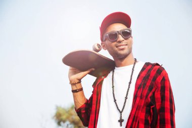 Çekici koyu tenli adam kaykay holding