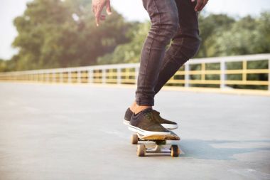 Genç koyu tenli adam kaykay