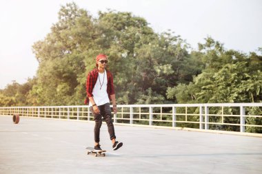 Genç çekici koyu tenli adam kaykay