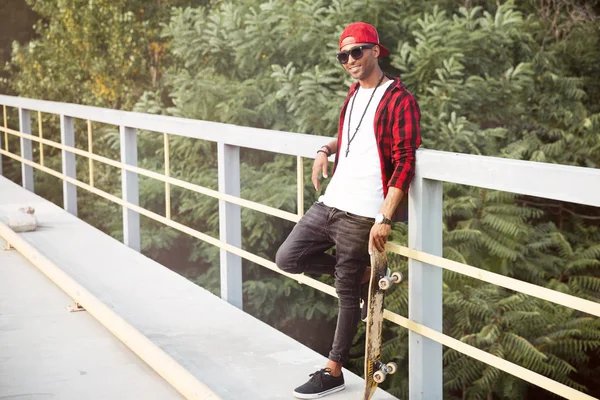 Mutlu koyu tenli adam kaykay holding