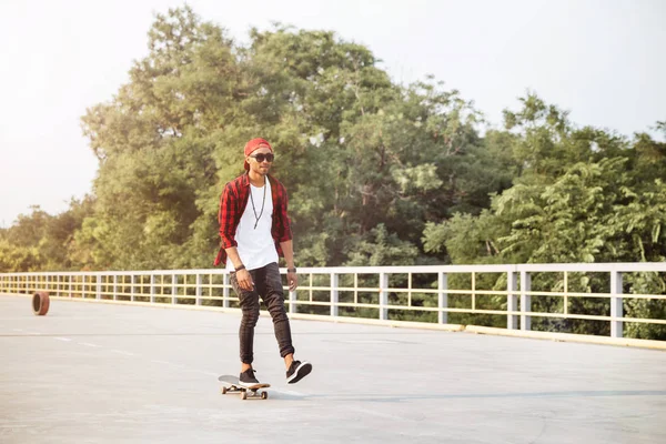 Genç çekici koyu tenli adam kaykay