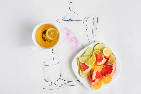 Xícara de chá, um prato com fatias de limão, toranja e laranja — Fotografia de Stock