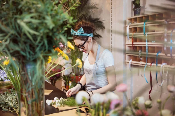 Mulher florista fazendo buquê e trabalhando na loja de flores — Fotografia de Stock