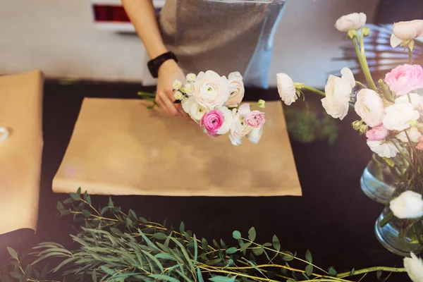Handen van vrouwelijke bloemist maakt boeket op de zwarte tabel — Stockfoto