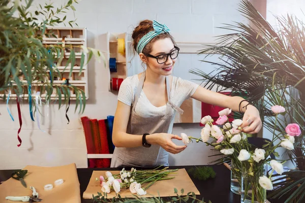 Smiling woman florist making bouquet in flower shop — Stock Photo, Image