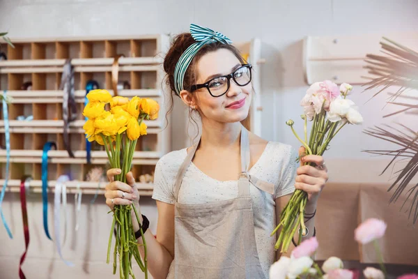 Mujer feliz florista sosteniendo flores blancas y amarillas en la tienda —  Fotos de Stock