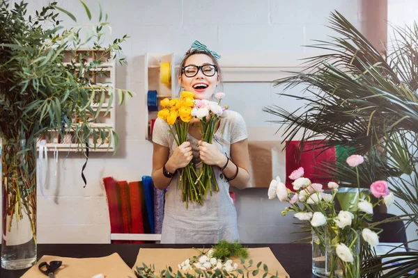 Mujer feliz florista con ramo de flores de pie y riendo —  Fotos de Stock