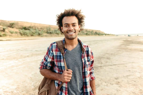 Glada afrikanska mannen står utomhus och hålla ryggsäck — Stockfoto