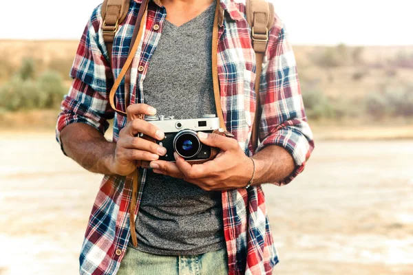 Man in plaid shirt houden oude vintage fotocamera — Stockfoto