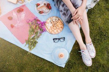 Paket üzerinde oturan ve piknik genç kadının bacakları
