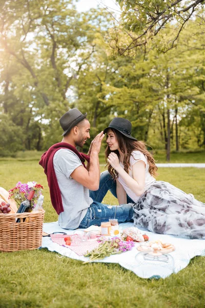 Usmívající se mladý pár s piknik v parku — Stock fotografie