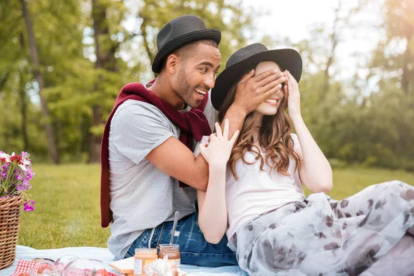 活泼开朗的年轻人覆盖他的女友在公园里的眼睛 — 图库照片