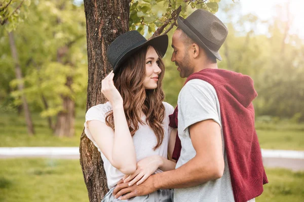 Šťastný mladý pár postavení a objímat v parku — Stock fotografie