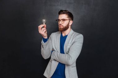 Genç dalgın ampul üzerinde seyir gözlük erkekte sakallı