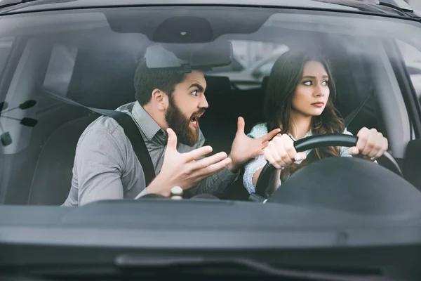 Unhappy woman and man in car