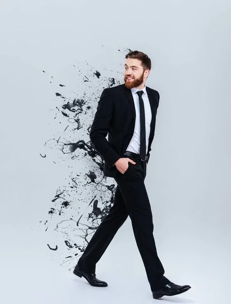 Retrato de um homem de negócios barbudo sorridente em terno preto andando — Fotografia de Stock