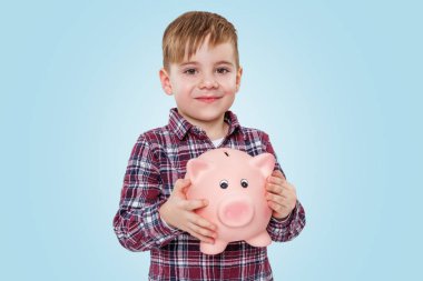 Domuz para kutusu tutarak gülümseyen bir küçük çocuk portresi