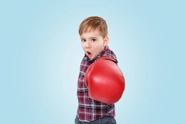 Angry little boy with red boxing gloves punching at camera — Stock Photo, Image