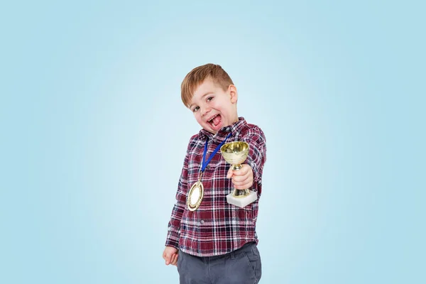 Alegre niño mostrando trofeo taza —  Fotos de Stock