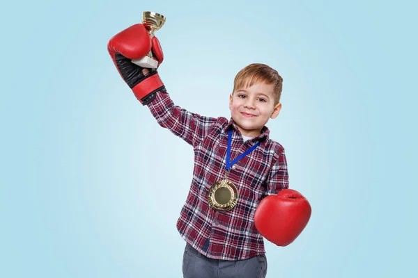 Jongen het dragen van bokshandschoenen en vieren van succes met gouden trofee — Stockfoto