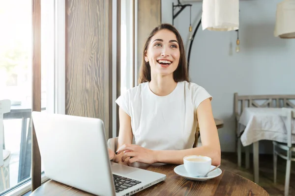 Riendo hermosa chica con portátil en el restaurante — Foto de Stock