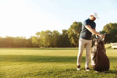Genç adam Golf Kulübü bir çantasından alarak