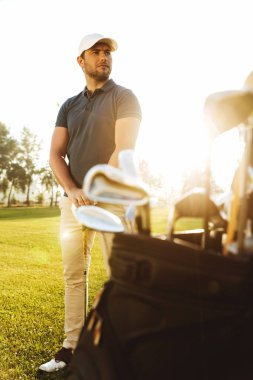 Erkek golf oyuncu kulübü torbayla yeşil sahasında