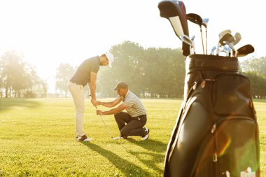 Kişisel antrenör bir genç erkek golfçü için bir ders vermek