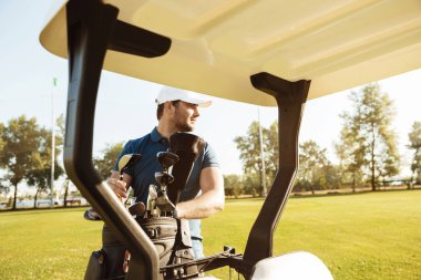 Bir torba içinde bir golf arabası kulüpleri alarak golfçü