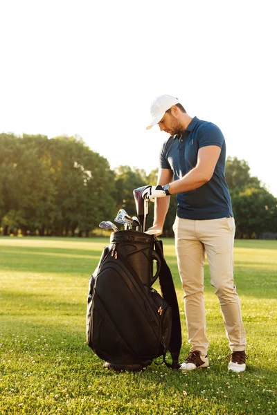 Молодий чоловік тримає гольф клуб — стокове фото