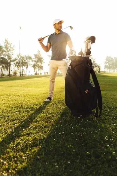 Yeşil alan üzerinde duran genç erkek golfçü