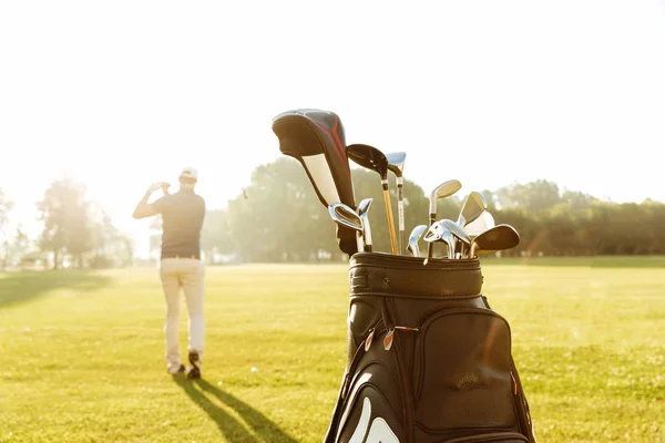 Visão traseira de um golfista masculino balançando clube de golfe — Fotografia de Stock