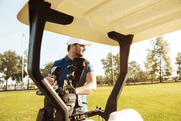 Golfista biorąc kluby z worka w wózek golfowy — Zdjęcie stockowe