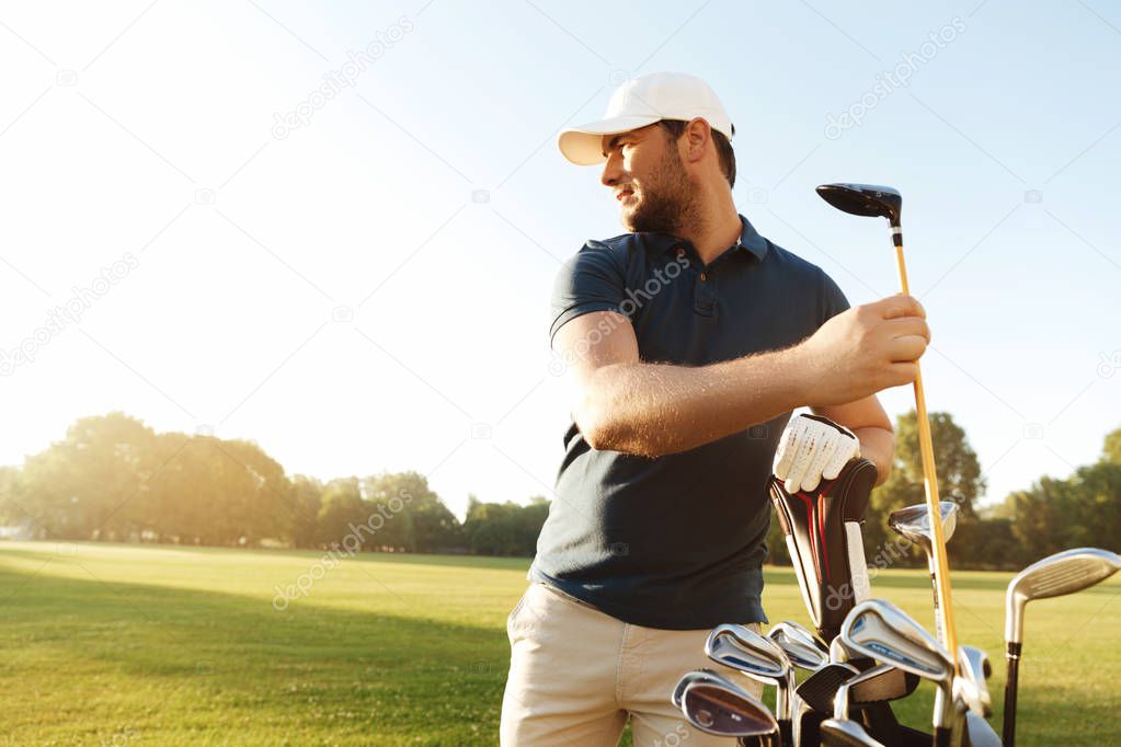 Man golfer taking out the golf club from a bag