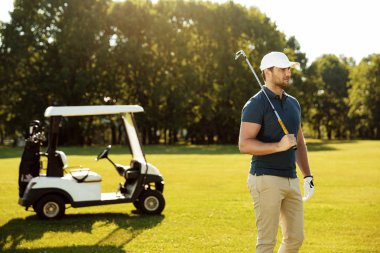 Golf kulübü ayakta ile genç erkek golfçü