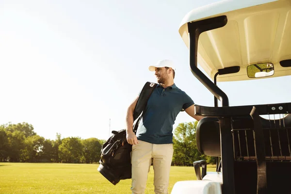 Młody mężczyzna stojący z torby golfowej — Zdjęcie stockowe