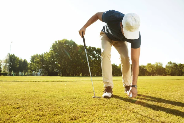 Mladý muž golfista uvedení golfový míček na tričko — Stock fotografie