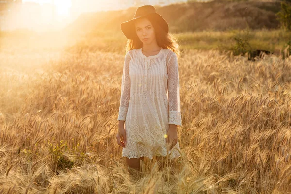 Bela jovem mulher de pé no campo — Fotografia de Stock