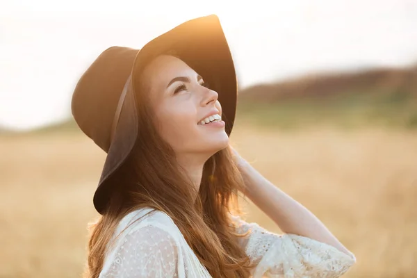 Cheerful young woman standing in the field — Stock Photo, Image