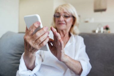 Cep telefonu kullaranarak gözlük Olgun kadın