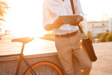 Yakışıklı genç Afrika adam erken sabah tablet bilgisayar kullanarak.