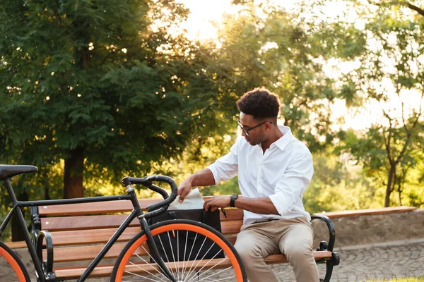 Konzentrierter junger Afrikaner frühmorgens mit Fahrrad — Stockfoto