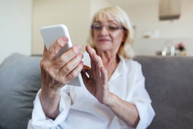 Cep telefonu kullaranarak gözlük Olgun kadın