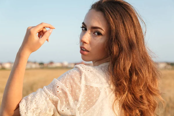 Úžasné vážné mladá žena stojící v poli — Stock fotografie