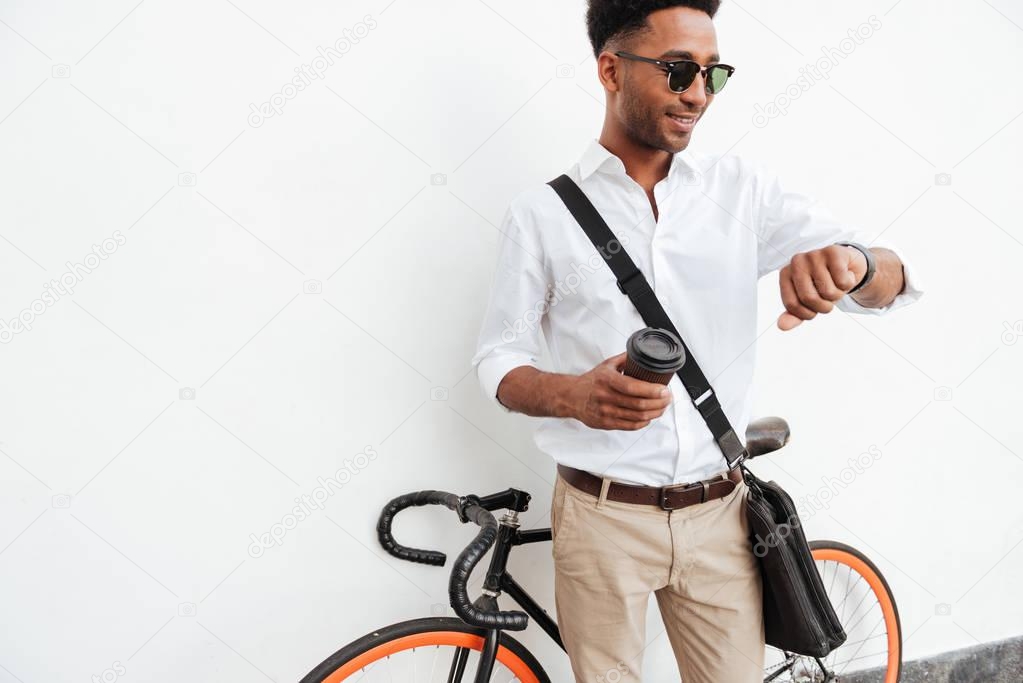 African man with bicycle drinking coffee.