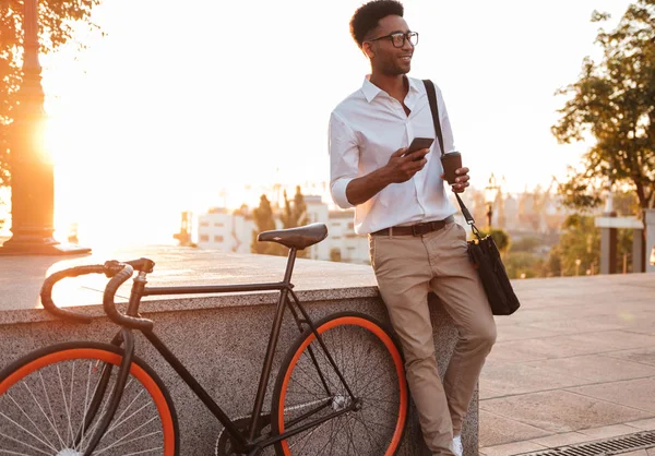 Afrikaner steht frühmorgens neben Fahrrad — Stockfoto