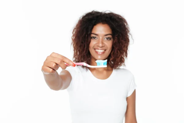 Afrikalı kadın diş macunu ile diş fırçası tutan. — Stok fotoğraf